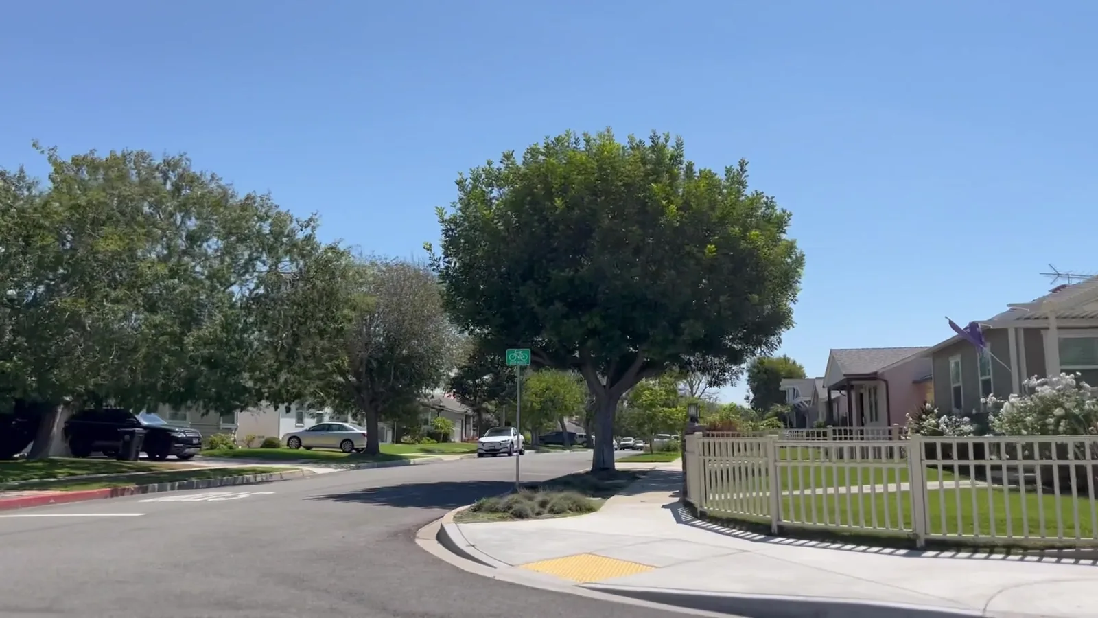 A residential street in Manhattan Beach with homes, yards, sidewalks and mature trees